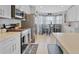 Well-lit kitchen featuring stainless steel appliances and a breakfast nook with checkered curtains at 1083 Snively Cir, Lake Hamilton, FL 33851