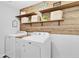 Organized laundry room with floating shelves, decor, and a wood accent wall at 1083 Snively Cir, Lake Hamilton, FL 33851