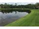 Expansive lawn with a picturesque view of the tranquil water feature at 12273 Pescara Ln, Orlando, FL 32827
