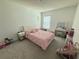Cozy bedroom with soft pink decor, a comfortable bed, and a vanity area, perfect for a room at 12273 Pescara Ln, Orlando, FL 32827