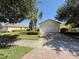 Charming home featuring a two-car garage, beautiful landscaping, and a brick-paved driveway at 12273 Pescara Ln, Orlando, FL 32827