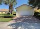 Charming home featuring a two-car garage, beautiful landscaping, and a brick-paved driveway at 12273 Pescara Ln, Orlando, FL 32827