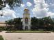 Exterior view of community town center featuring clock tower, manicured landscaping at 12273 Pescara Ln, Orlando, FL 32827