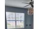 Bedroom featuring a large window for ample natural light, complemented by a modern ceiling fan and stylish light fixture at 130 Highland Meadows St, Davenport, FL 33837