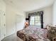 Comfortable bedroom includes a closet, bed with patterned bedding, and a window offering natural light at 1301 Rebecca Dr, Haines City, FL 33844