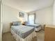 Cozy bedroom with twin beds, neutral carpet, and a window for natural lighting at 1301 Rebecca Dr, Haines City, FL 33844