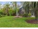 Lush backyard with a decorative fountain, pool enclosure, and mature palm trees at 133 Torino Ln, Kissimmee, FL 34759