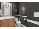 Powder room featuring a white vanity, toilet, framed artwork, and olive-green walls at 133 Torino Ln, Kissimmee, FL 34759