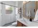 Modern bathroom with a glass-enclosed shower, white countertop, and an elegant framed mirror at 133 Torino Ln, Kissimmee, FL 34759