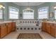 A luxurious bathroom features a large soaking tub surrounded by tiled accents, dual vanities, and ample natural light at 133 Torino Ln, Kissimmee, FL 34759