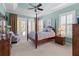 Primary bedroom with sitting area and ensuite bath. Four poster bed and neutral carpet at 133 Torino Ln, Kissimmee, FL 34759