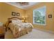 Comfortable bedroom featuring a floral comforter, ceiling fan, and a bright window providing ample natural light at 133 Torino Ln, Kissimmee, FL 34759