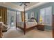 A beautifully decorated bedroom with tray ceilings, a four-poster bed, and access to an outdoor patio at 133 Torino Ln, Kissimmee, FL 34759