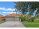 Charming house with a brick driveway, two-car garage, terra cotta roof, and lush landscaping with mature palms at 133 Torino Ln, Kissimmee, FL 34759