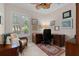 Home office featuring a large wooden desk, wicker chair, and natural light from the window at 133 Torino Ln, Kissimmee, FL 34759
