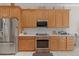 Kitchen with wood cabinets, stainless steel appliances and oven, and white countertops at 133 Torino Ln, Kissimmee, FL 34759