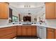 Kitchen island with stainless steel appliances, white countertops, and wood cabinets at 133 Torino Ln, Kissimmee, FL 34759