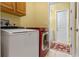 Laundry room with side-by-side washer and dryer, cabinets, and access to extra storage space at 133 Torino Ln, Kissimmee, FL 34759