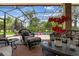 Enclosed patio featuring wicker furniture, a pink flamingo float in the pool, and views of the backyard at 133 Torino Ln, Kissimmee, FL 34759