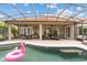 Inviting screened pool area with covered patio, outdoor seating and a pink flamingo float at 133 Torino Ln, Kissimmee, FL 34759