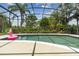 Relaxing screened-in pool and patio with lush greenery and a view of the backyard at 133 Torino Ln, Kissimmee, FL 34759