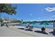 Scenic lake view with Adirondack chairs and green umbrellas, providing a serene spot for relaxation and community gathering at 1411 Celebration Ave # 106, Celebration, FL 34747