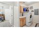 Functional laundry room with washer, dryer, sink, cabinets and access to adjacent bedroom at 1411 Celebration Ave # 106, Celebration, FL 34747