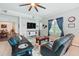 Comfortable living room featuring leather sofas, ceiling fan, area rug, and ample natural light at 1411 Celebration Ave # 106, Celebration, FL 34747