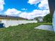 Backyard featuring lush green grass, a white fence, and a stone patio at 145 Willow Dr, Poinciana, FL 34759