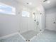 Modern bathroom featuring a glass shower with gray tile floor, decorative tile floor, and light blue walls at 145 Willow Dr, Poinciana, FL 34759