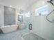 Modern bathroom featuring a glass shower, sleek vanity, mosaic tile accent wall, and a freestanding tub at 145 Willow Dr, Poinciana, FL 34759