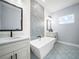 Modern bathroom featuring a soaking tub, patterned tile floor, and dual vanities with black hardware and fixtures at 145 Willow Dr, Poinciana, FL 34759