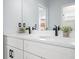 Bathroom featuring double sinks, white cabinets, quartz countertops, and matte black hardware at 145 Willow Dr, Poinciana, FL 34759