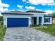 Charming single-Gathering home featuring blue exterior, a blue garage door, and manicured landscaping at 145 Willow Dr, Poinciana, FL 34759