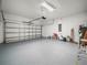 Spacious garage featuring an epoxy floor, brick walls, and an automatic door opener at 145 Willow Dr, Poinciana, FL 34759
