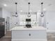 Bright kitchen with island, granite counters, stainless appliances, pendant lighting, and an adjacent pantry at 145 Willow Dr, Poinciana, FL 34759