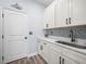Well-organized laundry room with stylish tile backsplash, ample cabinet space, and modern sink at 145 Willow Dr, Poinciana, FL 34759