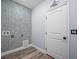 Spacious laundry room with mosaic tile wall, utility connections, and a clean, bright atmosphere at 145 Willow Dr, Poinciana, FL 34759