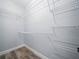 Bright walk-in closet featuring wire shelving along the walls for efficient storage solutions at 145 Willow Dr, Poinciana, FL 34759
