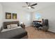 Cozy bedroom with a ceiling fan, streamlined furniture, and a computer gaming setup illuminated by natural light from bright windows at 1809 Bluepoint St, St Cloud, FL 34771