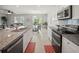 Open kitchen with modern appliances, granite countertops, island with seating, and access to the living and dining area at 1809 Bluepoint St, St Cloud, FL 34771