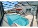Sparkling pool inside screened enclosure with patio, umbrella, and exterior view of the house at 1809 Bluepoint St, St Cloud, FL 34771