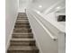 Modern stairway featuring white rails and stained wood steps, leading to the upper level at 1809 Bluepoint St, St Cloud, FL 34771