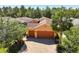 A sunny aerial view of the home shows a charming home featuring a three-car garage at 1825 Pelican Hill Way, Kissimmee, FL 34759