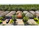 An aerial view showing a home with a well-manicured lawn and brick driveway in a lush neighborhood at 1825 Pelican Hill Way, Kissimmee, FL 34759