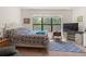 Bright bedroom featuring a queen-sized bed, modern rug, and view from the large window at 1825 Pelican Hill Way, Kissimmee, FL 34759