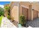 A partial view of the house shows the charming two-car garage, lush landscaping, and meticulous walkway at 1825 Pelican Hill Way, Kissimmee, FL 34759