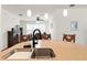 Bright kitchen featuring a large island with a stainless steel sink, pendant lights, and an open view to the dining area at 1825 Pelican Hill Way, Kissimmee, FL 34759