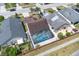 Aerial view of a home with a screened pool enclosure and a well-maintained backyard and patio at 2049 Shannon Lakes Blvd, Kissimmee, FL 34743