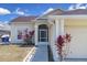 Inviting front entrance with a screen door, pathway, and colorful plants around the exterior at 2049 Shannon Lakes Blvd, Kissimmee, FL 34743